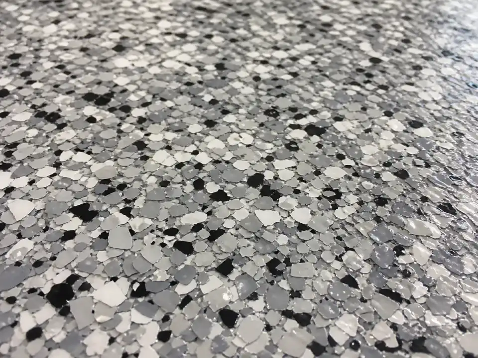 Close-up of gray-and-black decorative flakes in an Atlanta garage coating